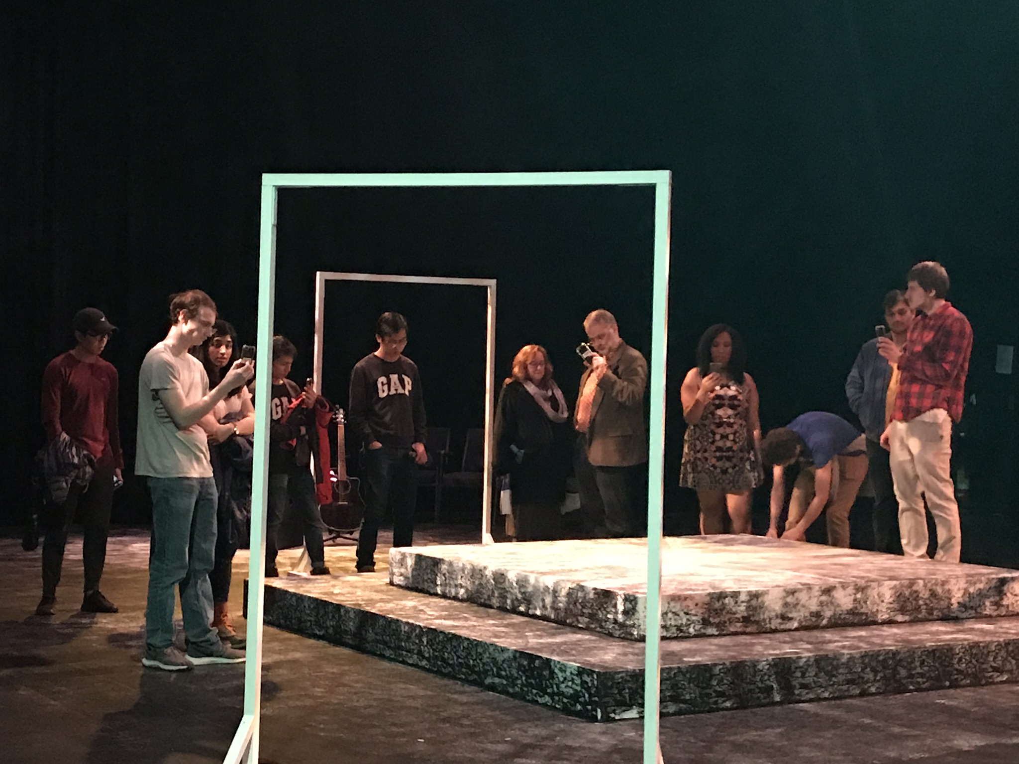 Audience members use phones around the stage during The Safety Show